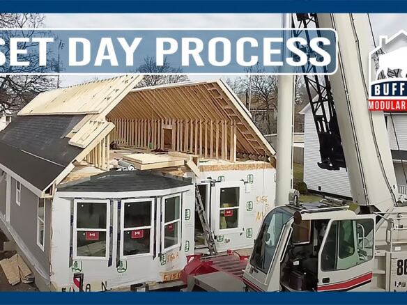 Crane setting a modular home on its foundation on a city lot in Buffalo, NY